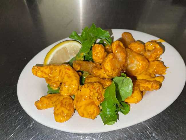 Delicious bang bang shrimp served with lettuce and a lemon presented to you by Cheers Grille & Bar in Concord NH.