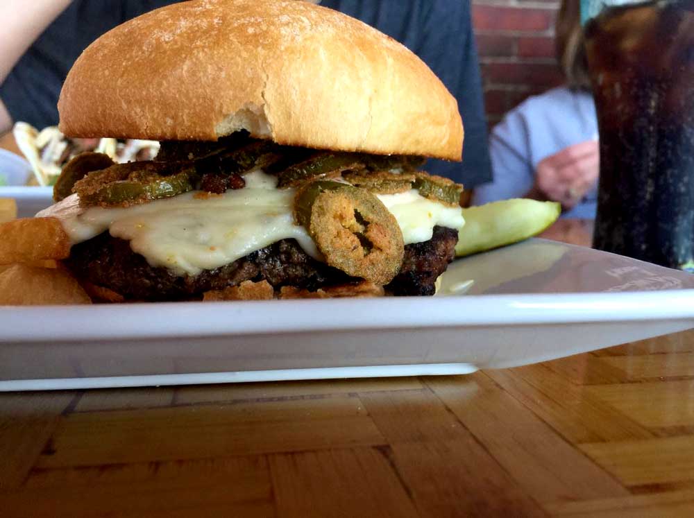 Delicious burger served with melted cheese and breaded jalapenos at Cheers Grille & Bar in Concord NH.