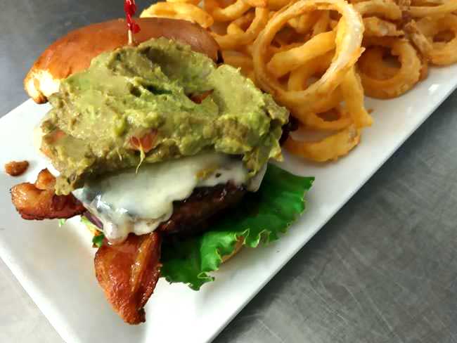 Enjoy a hot a delicious cali burger served with onion rings at Cheers Grille & Bar in Concord NH.