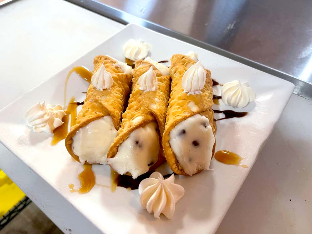 Delectable cannolis served with whipped cream and chocolate syrup at Cheers Grille & bar in Concord NH.