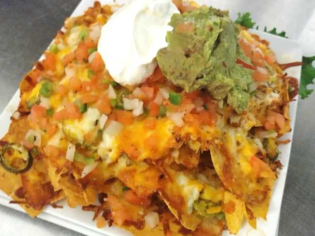If you're craving chicken nachos with corn chips, cheese jalapenos, pico de gallo, topped with guacamole and sour cream stop in at Cheers Grille & Bar in Concord NH.