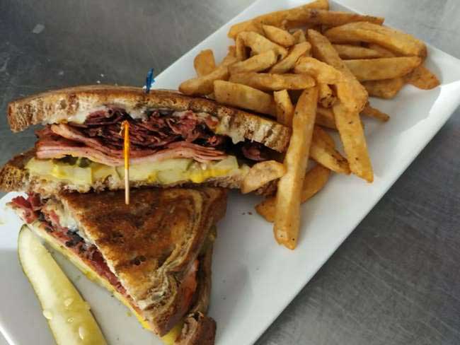 Enjoy a classic rueban sandwich served with fries and a pickle at Cheers Grille & Bar in Concord NH.