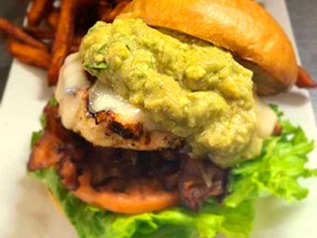 Enjoy a west coast chicken sandwich with guacamole, lettuce, melted cheese and bacon served best at Cheers Grille & Bar in Concord NH.